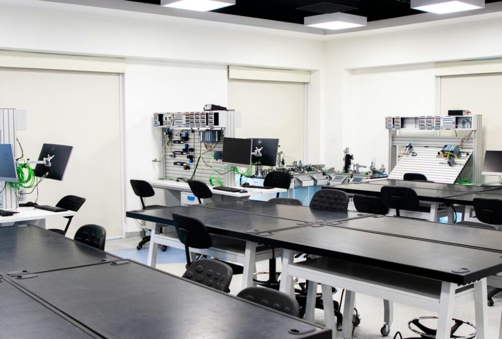 Spacious and modern technology lab featuring desks and computer equipment, ideal for educational settings.