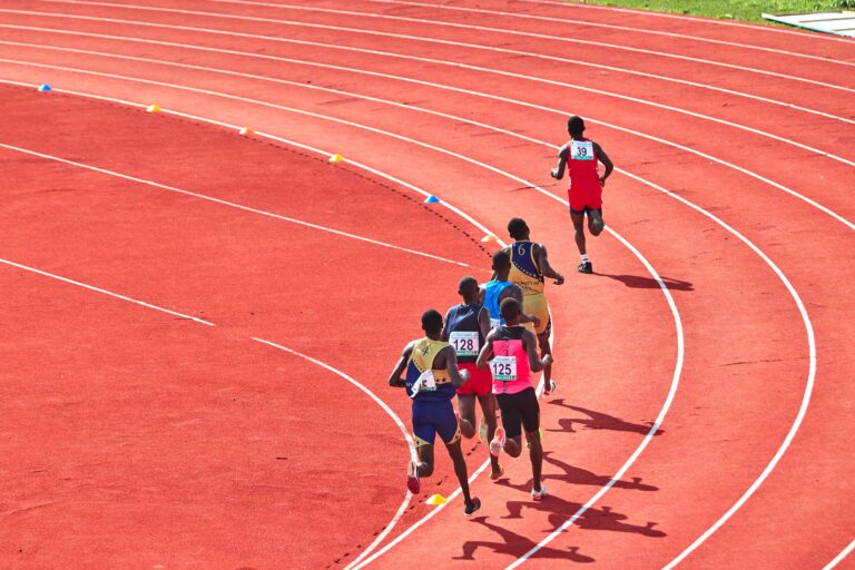 Academics A group of athletes running on a curved outdoor track in a competitive race.
